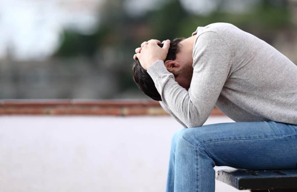Man looking down during a difficult moment in recovery from carfentanil addiction in Nashville.