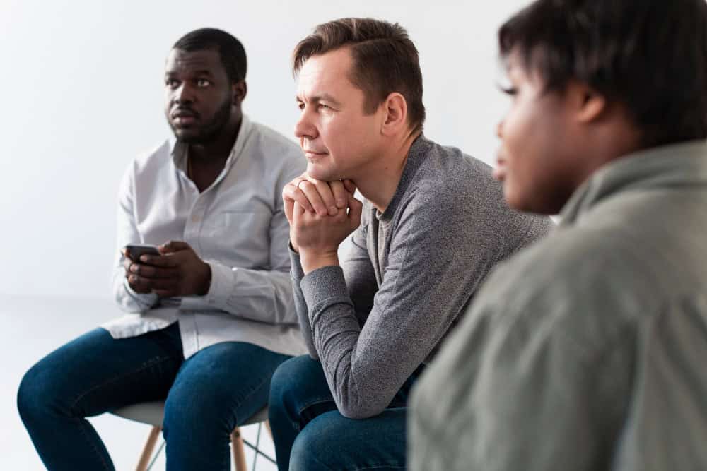 Thoughtful man and woman participating in group therapy focused on undiagnosed ADHD in adults.